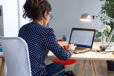 Frau am Arbeitsplatz zu Hause, arbeitet im Homeoffice am Laptop
