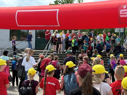 Kinder der Sportabzeichen-Challenge verlassen mit Schirmmützen und Urkunden die Veranstaltung 
