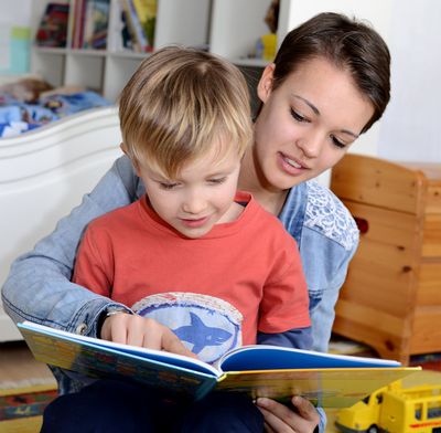 Babysitterin liest Kind im Buch vor, Link zu vollständigem Artikel