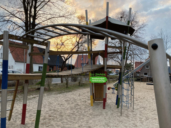 Hangelbogen auf einem Oldenburger Spielplatz mit Klettergerüst im Hintergrund