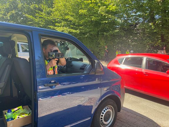 Aus einem blauen Bulli erfolgt eine Geschwindigkeitsmessung durch den Kontaktbeamten der Polizei