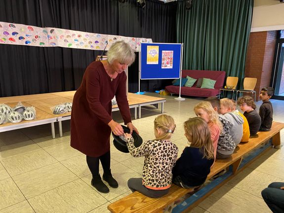 Förderschulrektorin, Marianne Wesselmann, nimmt mit Erstklässlerinnen/Erstklässlern des Albert-Schweitzer-Förderzentrums die Verlosung vor