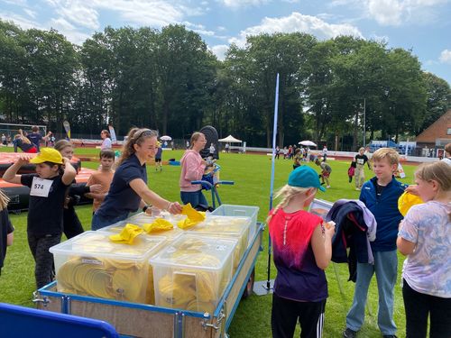 Theresa Wieting beim Verteilen der sonnig-gelben GUV OL-UV-Schutz-Cappis an die Grundschulkinder 