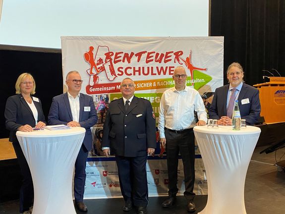 Vertreter und Vertreterinnen der beteiligten Institutionen vor dem Textildisplay des Fachtags