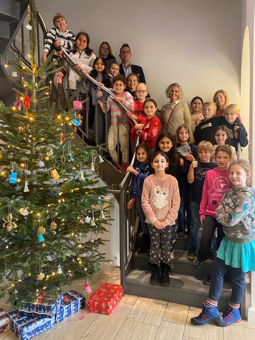 Drittklässlerinnen und Drittklässler der Grundschule Hogenkamp schmücken den Weihnachtsbaum des GUV OL 