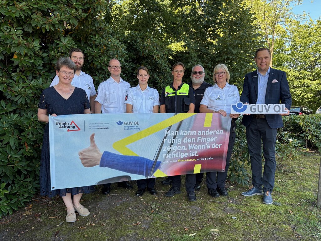 Mit dem Banner der Verkehrssicherheitskampagne #MehrAchtung und dem Slogan "Man kann anderen ruhig den Finger zeigen, wenn's der richtige ist." werden Verkehrsteilnehmende vor der Janosch-Grundschule auf angemessenes Verhalten im Straßenverkehr aufmerksam gemacht 