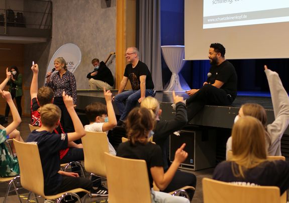 Anja Monz, Dr. Axel Gänsslen und Adel Tawil im Gespräch mit den 6. Klässlerinnen und Klässlern der IGS Flötenteich im Rahmen der Unterrichtseinheit