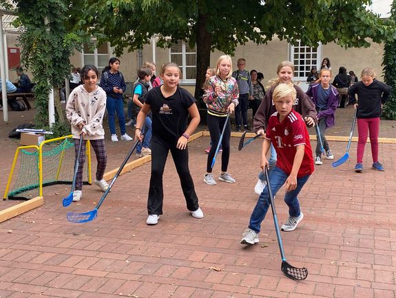 Sechstklässlerinnen und -klässler des CAG spielen Pausenhockey 