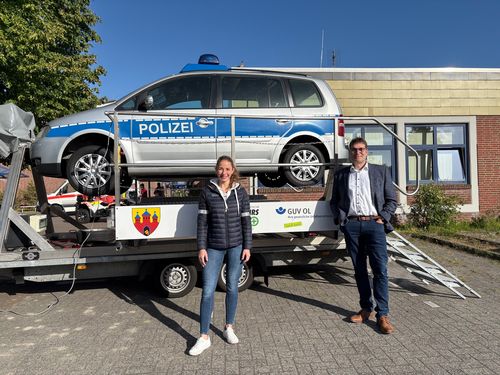 Verkehrssicherheit praxisnah & anschaulich vermitteln - Dr. Ole Westerhoff, Schulleitung BBS Wechloy, und Theresa Wieting, Präventionsberaterin GUV OL  des GUV OL, vor dem Überschlagssimulator