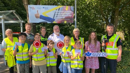 Ein starkes Präventionsteam - Schulleitung, Polizistinnen und Polizisten der Polizeiinspektion OL-Stadt/Ammerland sind zusammen bei einer Verkehrsaktion mit fünf Schülerinnen und Schülern der Brakenhoffschule und der Präventionsberaterin des GUV OL unter dem Banner "Mann kann anderen ruhig den Finger zeigen. Wenn´s der richtige ist."