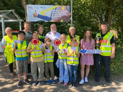 Ein starkes Präventionsteam - Schulleitung, Polizistinnen und Polizisten der Polizeiinspektion OL-Stadt/Ammerland sind zusammen bei einer Verkehrsaktion mit fünf Schülerinnen und Schülern der Brakenhoffschule und der Präventionsberaterin des GUV OL unter dem Banner "Mann kann anderen ruhig den Finger zeigen. Wenn´s der richtige ist."