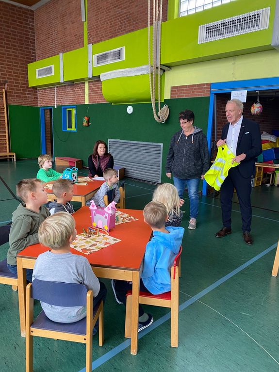 Geschäftsführer informiert Kinder über Unfallprävention mit Sicherheitsweste