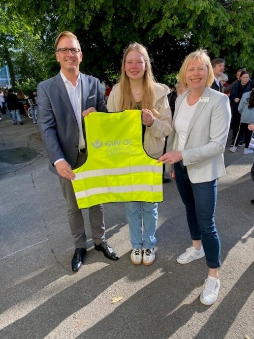 Landrat Stephan Siefken, Schülervertreterin Rieke Dirks und Angela Pauka mit einer der 350 Sicherheitswesten des GUV OL