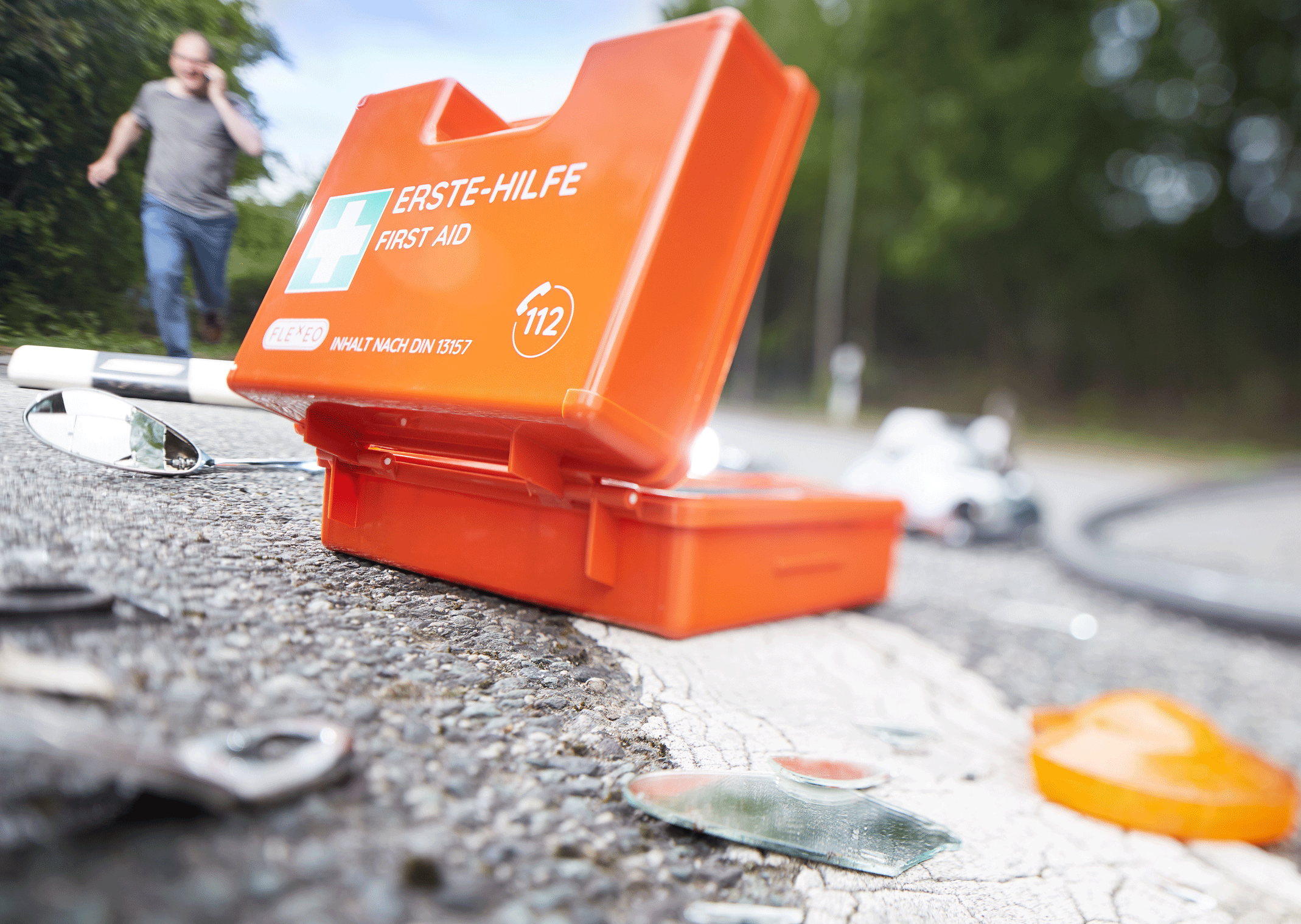 Aufgeklappter Erste-Hilfe-Koffer auf der Straße liegend, wie zum Einsatz bei einem Unfall